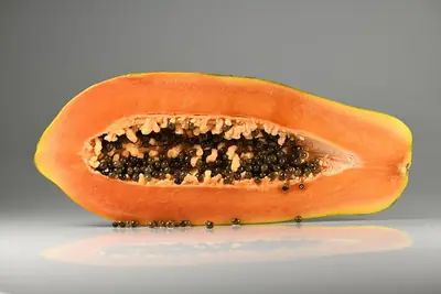 A pawpaw cut lengthways, showing its seeds